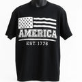 Black short sleeve graphic t shirt featuring a distressed American flag design with America EST 1776 text in a vintage patriotic style.