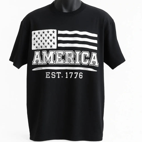 Black short sleeve graphic t shirt featuring a distressed American flag design with America EST 1776 text in a vintage patriotic style.