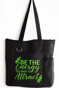 Black tote bag featuring the motivational quote “Be the Energy You Attract” in bright green typography. Stylish everyday tote with strong shoulder straps for shopping, work, school, travel, errands, books, groceries, and daily essentials. Inspirational quote bag designed for positive mindset, self-growth, mindfulness, confidence, and uplifting everyday fashion.