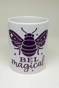White ceramic mug featuring a purple bee illustration and the uplifting phrase "Bee Magical." Perfect coffee mug for bee lovers, nature lovers, gardeners, teachers, coworkers, friends, and family. Ideal for coffee, tea, hot cocoa, birthdays, holidays, appreciation gifts, and everyday inspiration.
