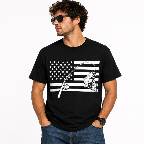 A man wearing a black short-sleeve t-shirt with a white graphic of a fishing rod and fish over an American flag design, paired with blue jeans and sunglasses, against a plain white background.
