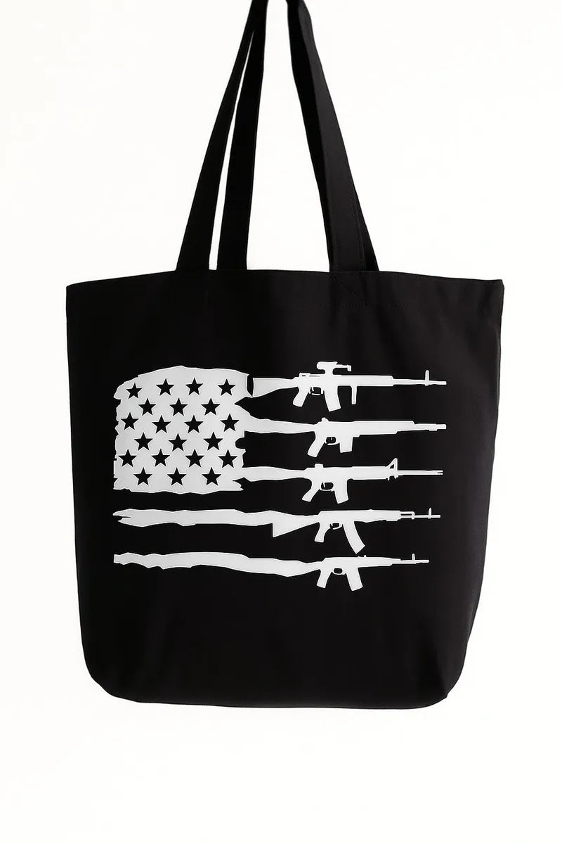 Black cotton tote bag with distressed white American flag rifle graphic design, reusable patriotic shoulder tote for shopping, travel, work, daily errands, and everyday carry with bold USA inspired artwork