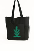 Black tote bag featuring a green botanical leaf design on the front. Lightweight reusable shoulder tote with long handles for comfortable carrying. Ideal for shopping, work, books, errands, travel, farmers markets, and everyday use. Nature-inspired tote bag with a minimalist botanical aesthetic that pairs easily with casual and modern outfits. Durable and practical carryall bag suitable for women, students, teachers, plant lovers, gardeners, and eco-conscious shoppers looking for a stylish everyday accessor
