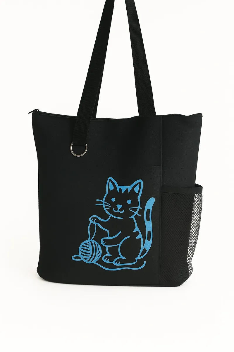 Black tote bag featuring a blue cat graphic design on the front. Lightweight reusable shoulder tote with long handles for comfortable carrying. Perfect for shopping, books, work, travel, errands, school, and everyday use. Stylish cat artwork adds a fun and modern touch to this practical carryall tote. Ideal for cat lovers, pet owners, students, teachers, and anyone looking for a fashionable and functional everyday tote bag.