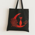 Black cotton tote bag with red crescent moon cat graphic design, reusable gothic shoulder bag for shopping, school, travel, spooky fashion, and cat lovers.