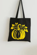 Black cotton tote bag with yellow pumpkin graphic design, reusable fall shoulder bag for shopping, travel, school, Halloween season, and autumn fashion lovers