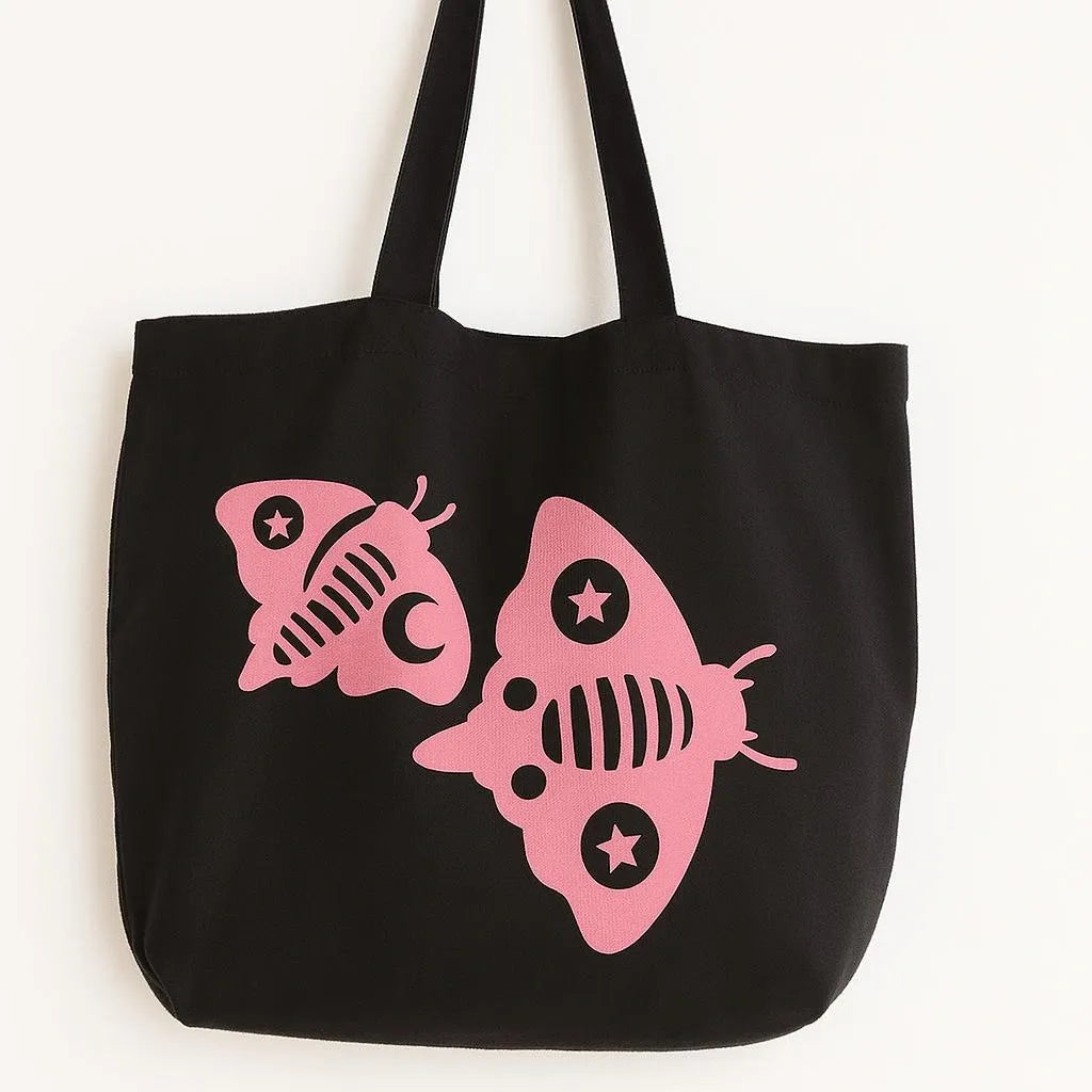Black cotton tote bag with pink fish graphic design, reusable shoulder tote for beach trips, shopping, travel, ocean lovers, summer style, everyday carry bag with cute tropical fish artwork and durable fabric straps