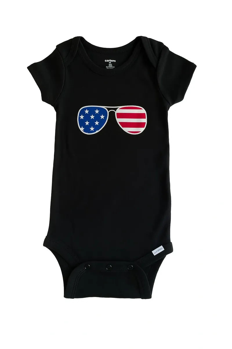 Black baby bodysuit featuring a patriotic USA sunglasses graphic in red white and blue for infants and toddlers.