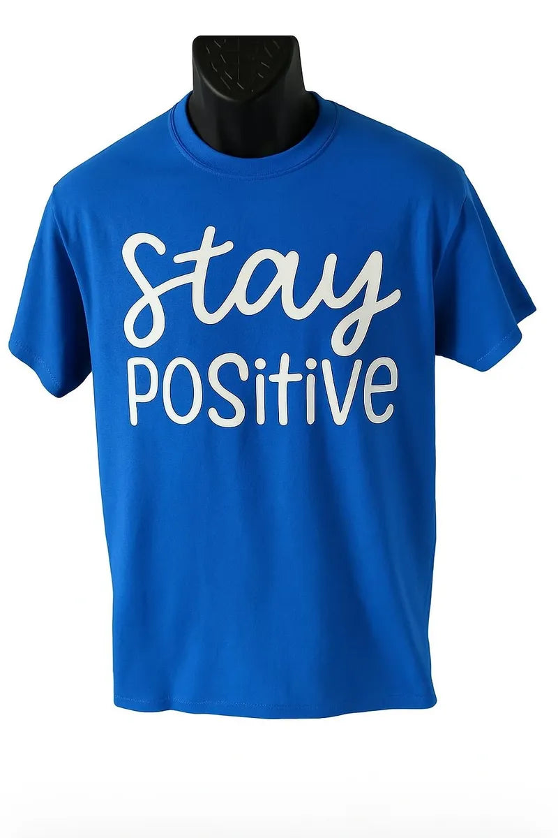 Blue graphic t shirt featuring the phrase Stay Positive in white script lettering on a bright blue unisex short sleeve tee designed for everyday casual wear.