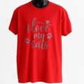 Red unisex graphic T shirt featuring the phrase "Love My Cats" in decorative typography with paw prints. Soft cotton casual tee for cat lovers, cat moms, cat dads, and pet enthusiasts.