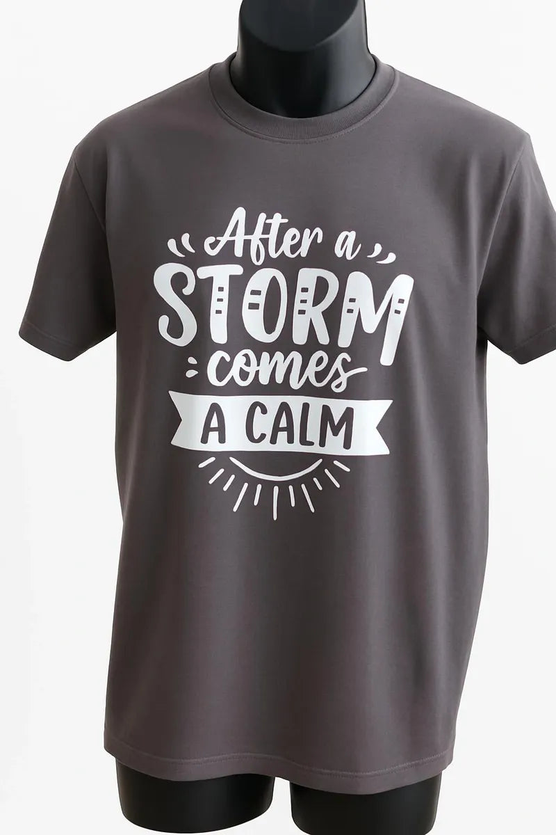 Charcoal gray graphic t shirt featuring the inspirational quote After the Storm Comes a Calm in a vintage typography design promoting hope, strength, and resilience.
