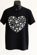 Black unisex graphic T shirt featuring a heart made from white paw prints for dog lovers, pet parents, dog moms, and dog dads.