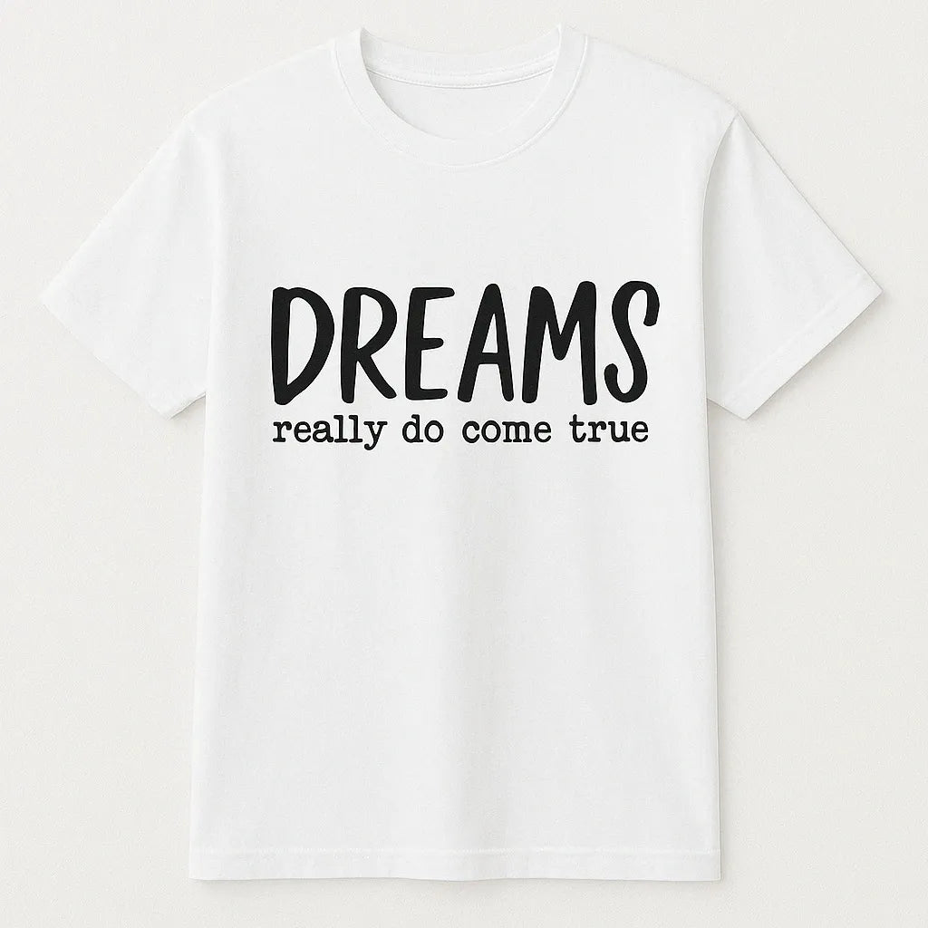White graphic t-shirt featuring the inspirational phrase "Dreams Really Do Come True" in bold black typography. Motivational unisex shirt designed for positivity, encouragement, goal setting, personal growth, and everyday casual wear.