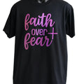Black graphic t-shirt featuring the phrase "Faith Over Fear" in stylish pink typography, inspirational motivational statement tee for everyday confidence and positivity.