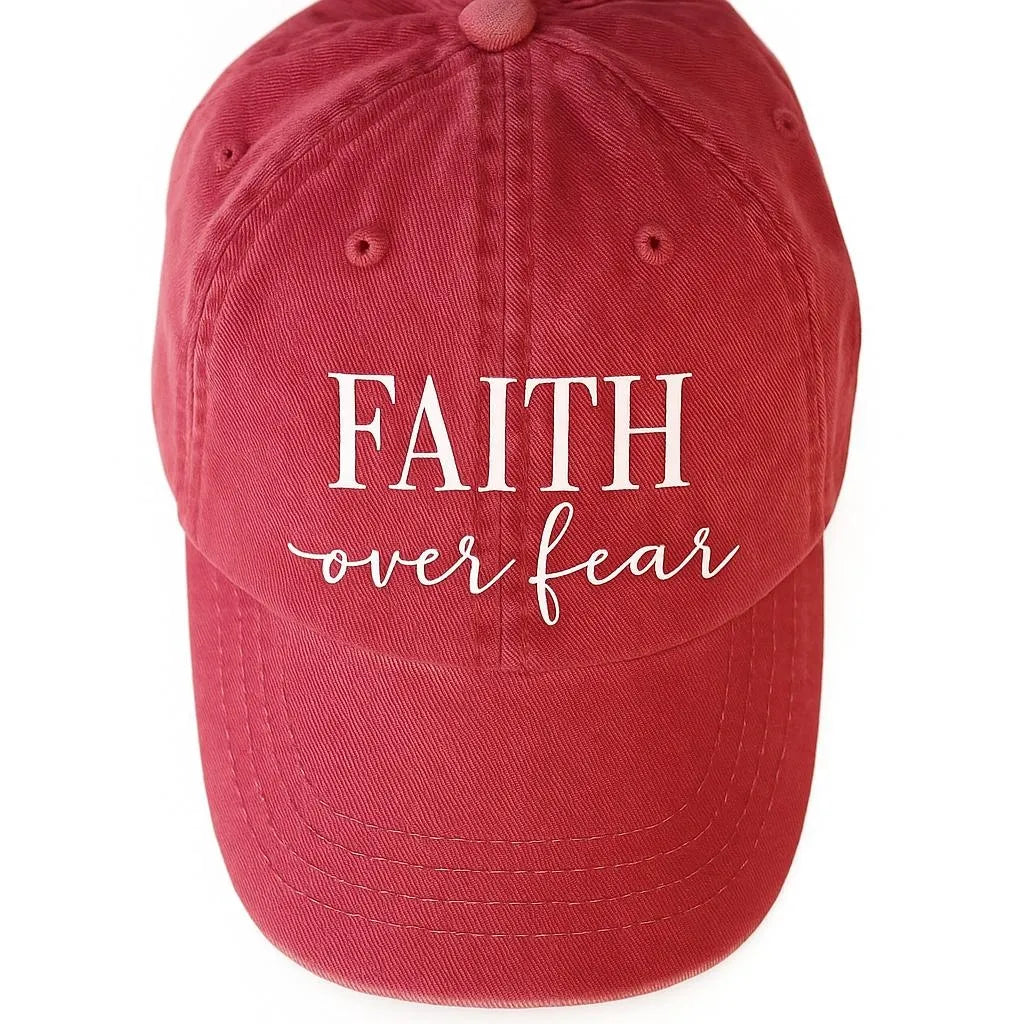 Red baseball cap featuring a white Faith Over Fear graphic design on the front with an adjustable back closure for casual everyday wear.