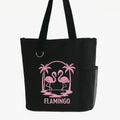 Black reusable tote bag featuring a pink flamingo tropical design with palm trees, stylish shoulder tote for beach trips, shopping, travel, groceries, vacations, and everyday use
