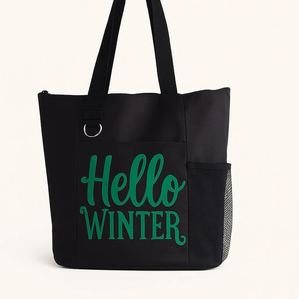 Black tote bag featuring the phrase "Hello Winter" in bold green lettering. Reusable winter-themed tote perfect for shopping, errands, holiday outings, work, travel, books, groceries, and everyday essentials. Lightweight and durable shoulder bag designed for winter lovers, seasonal gifting, and cozy cold-weather style.