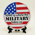 Round patriotic military coaster with American flag design and quote “Home Is Where the Military Takes Us,” decorative table coaster for military family home décor, veteran gift, patriotic coffee table accessory, red white blue farmhouse coaster, deployment homecoming gift, USA military decor accent for desk, dining table, office, and living room decoration.