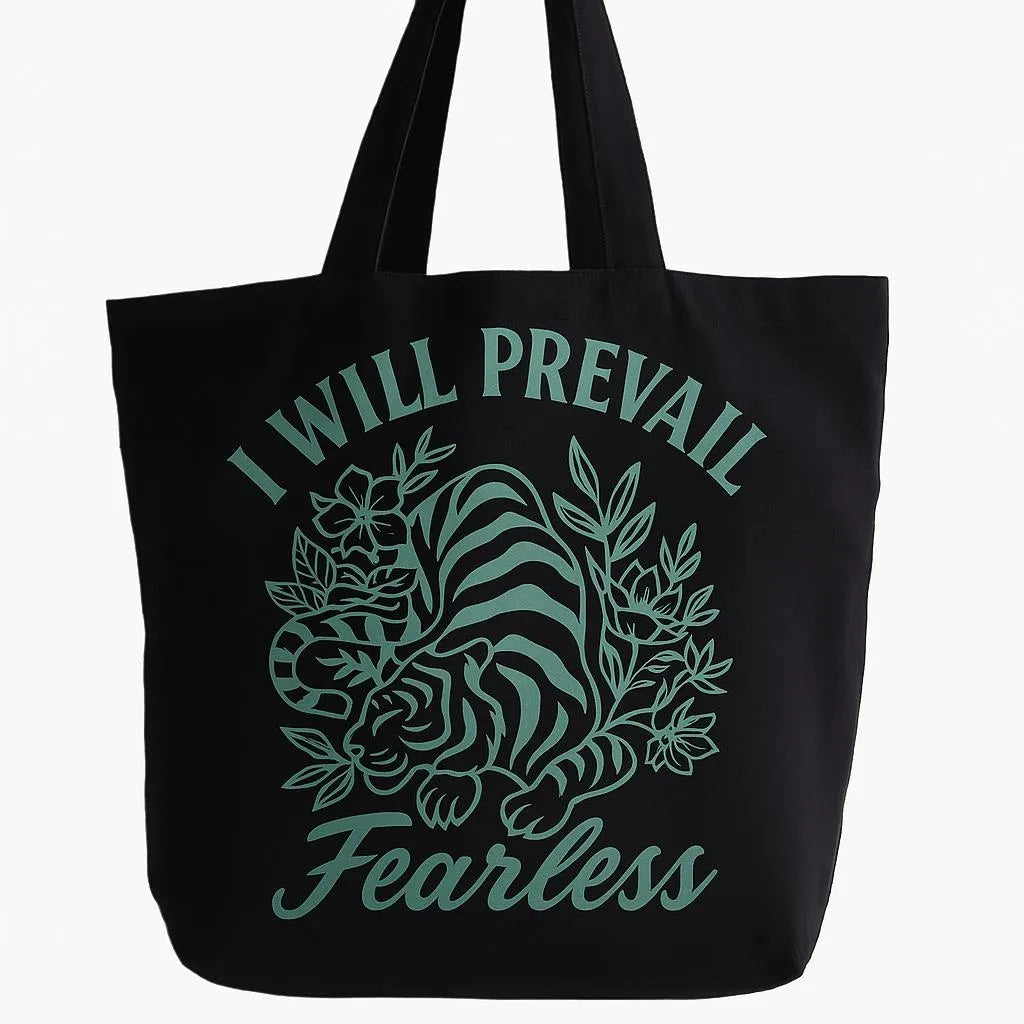 Black cotton tote bag with teal I Will Prevail Fearless lion graphic design, reusable motivational shoulder tote for shopping, work, school, travel, everyday carry, and inspirational lifestyle fashion