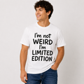 Male model wearing a white “I’m Not Weird, I’m Limited Edition” graphic T-shirt with bold black lettering and blue jeans.