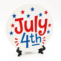 Round July 4th patriotic coaster featuring red white and blue lettering with stars. Perfect for Independence Day parties, patriotic home decor, and holiday table settings.