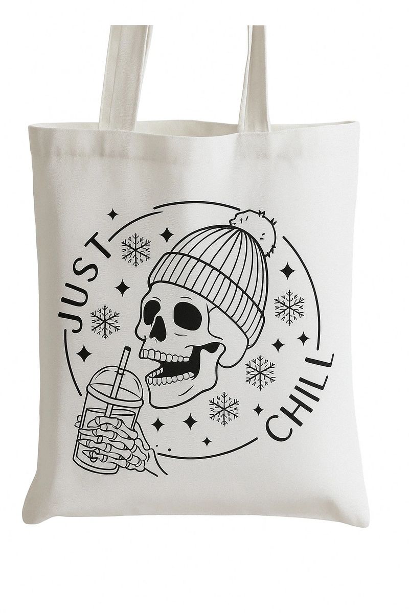 White canvas tote bag featuring a relaxed skeleton sipping an iced drink wearing a cozy beanie with Just Chill text in spooky minimalist style