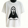 White graphic t-shirt featuring a playful ghost illustration and the phrase "Just Chillin," funny unisex Halloween-inspired graphic tee for casual wear.