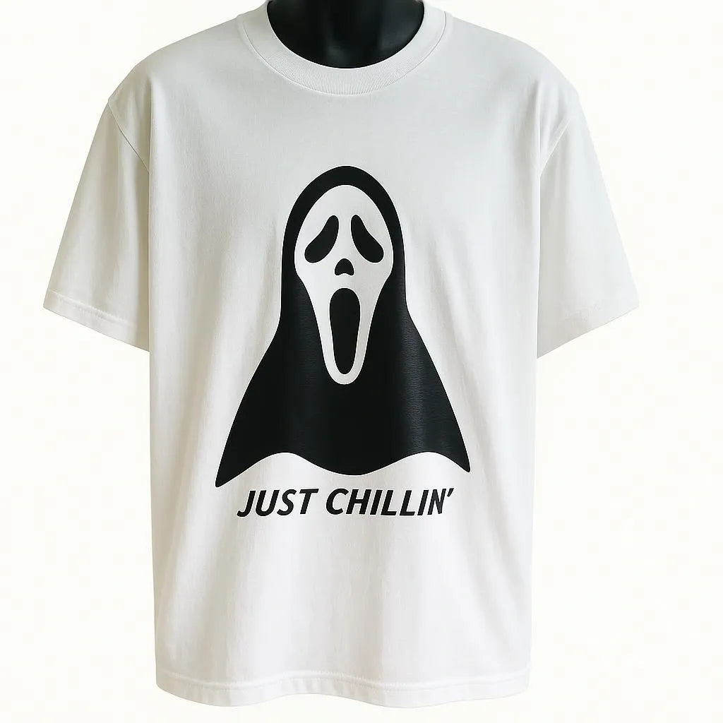 White graphic t-shirt featuring a playful ghost illustration and the phrase "Just Chillin," funny unisex Halloween-inspired graphic tee for casual wear.