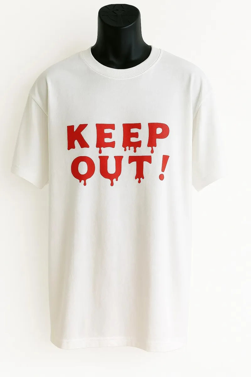 White graphic t-shirt featuring bold red "KEEP OUT!" text. Statement graphic tee with a clean, eye-catching design. Comfortable casual shirt perfect for streetwear, everyday outfits, weekend wear, travel, and anyone who enjoys bold typography fashion and expressive graphic apparel.