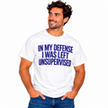 Man wearing a white In My Defense I Was Left Unsupervised graphic T-shirt with bold blue lettering.