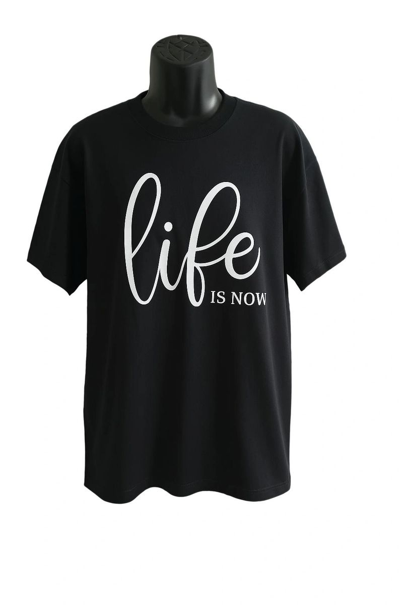Black unisex graphic T shirt featuring elegant white script reading "Life Is Now." Soft cotton casual tee with a clean minimalist typography design for everyday wear.
