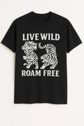 Black graphic t-shirt featuring a tiger illustration and the phrase "Live Wild Roam Free" in bold typography, adventure-inspired unisex graphic tee.