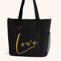 Black tote bag featuring the word "Love" in elegant gold script lettering. Minimalist reusable tote bag designed for shopping, work, travel, books, groceries, and everyday essentials. Stylish shoulder bag with a timeless inspirational design, perfect for gifting, daily use, and modern fashion lovers.