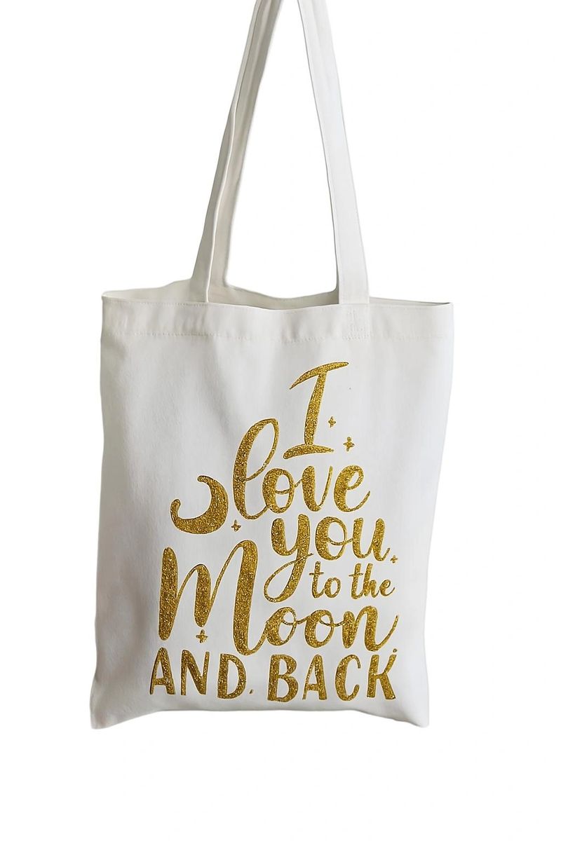 White canvas tote bag with gold “I Love You to the Moon and Back” quote design. Lightweight reusable shopping tote with elegant typography, minimalist style, and casual everyday carry look for gifting or daily errands.