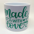 White ceramic mug featuring the phrase "Made With Love" in elegant green script lettering. Inspirational coffee mug perfect for coffee, tea, hot cocoa, and everyday beverages. Thoughtful gift for moms, teachers, coworkers, friends, bakers, crafters, creators, and anyone who appreciates meaningful drinkware.