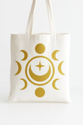 Moon phases celestial tote bag with golden lunar design and stars on reusable canvas shopping bag for spiritual style, books, errands, and everyday use.