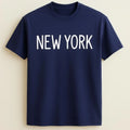 Navy blue graphic t-shirt featuring bold white "New York" typography. Comfortable unisex city-inspired shirt perfect for travel, casual wear, urban fashion, and NYC lovers.