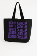 Black cotton tote bag with purple North Carolina typography design, reusable state pride shoulder bag for shopping, travel, school, and casual everyday style.