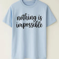 Blue graphic t-shirt featuring the inspirational quote "Nothing Is Impossible" in stylish black typography. Comfortable unisex motivational shirt for everyday wear, positivity, encouragement, and self-confidence.
