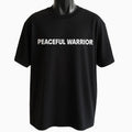 Black graphic t-shirt featuring the phrase "Peaceful Warrior" in clean white typography, inspirational unisex statement tee promoting strength, balance, and confidence.