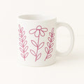 White ceramic mug featuring a delicate pink floral line art design with simple botanical flowers and leaves. Perfect for coffee, tea, hot cocoa, gifting, home decor, office use, floral lovers, gardeners, moms, teachers, and anyone who enjoys minimalist botanical drinkware.