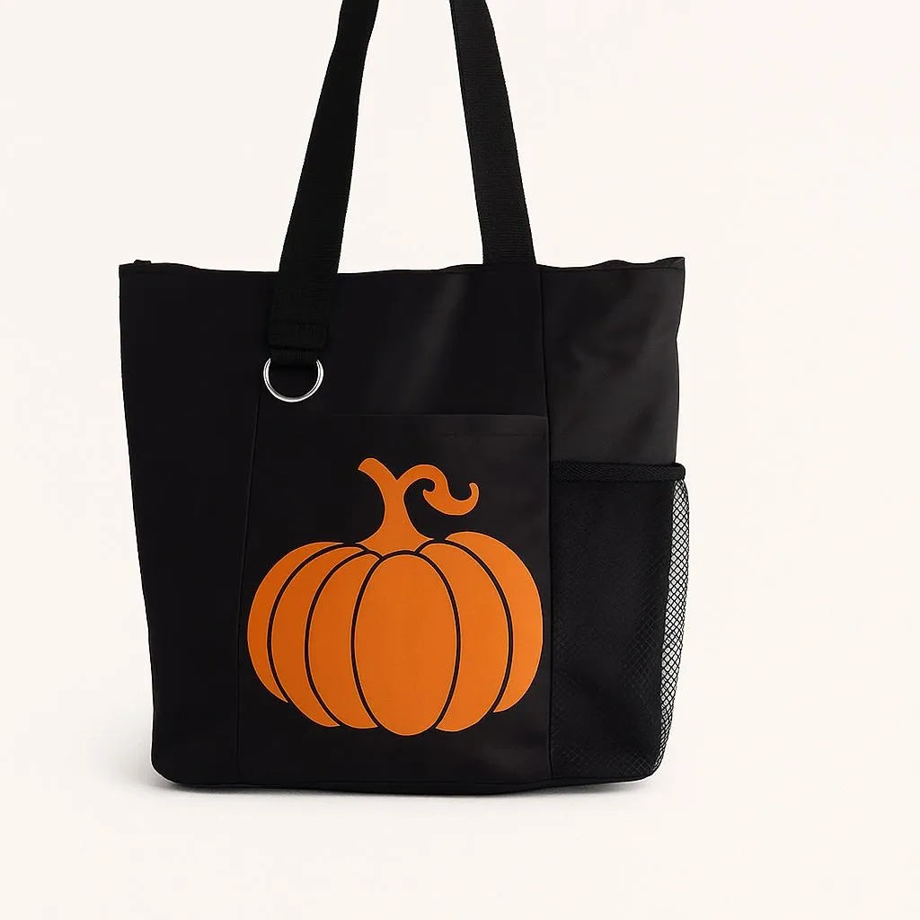 Black tote bag featuring a bright orange pumpkin graphic. Seasonal reusable tote perfect for fall festivals, Halloween events, shopping, errands, school, work, farmers markets, books, groceries, and everyday essentials. Lightweight and durable shoulder bag designed for autumn lovers and seasonal decorating enthusiasts