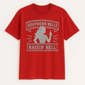 Red graphic T-shirt with “Southern Belle Raisin’ Hell” statement design displayed on a plain background