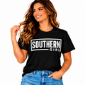 Woman wearing a black Southern Girl graphic T-shirt with bold white lettering and blue jeans.