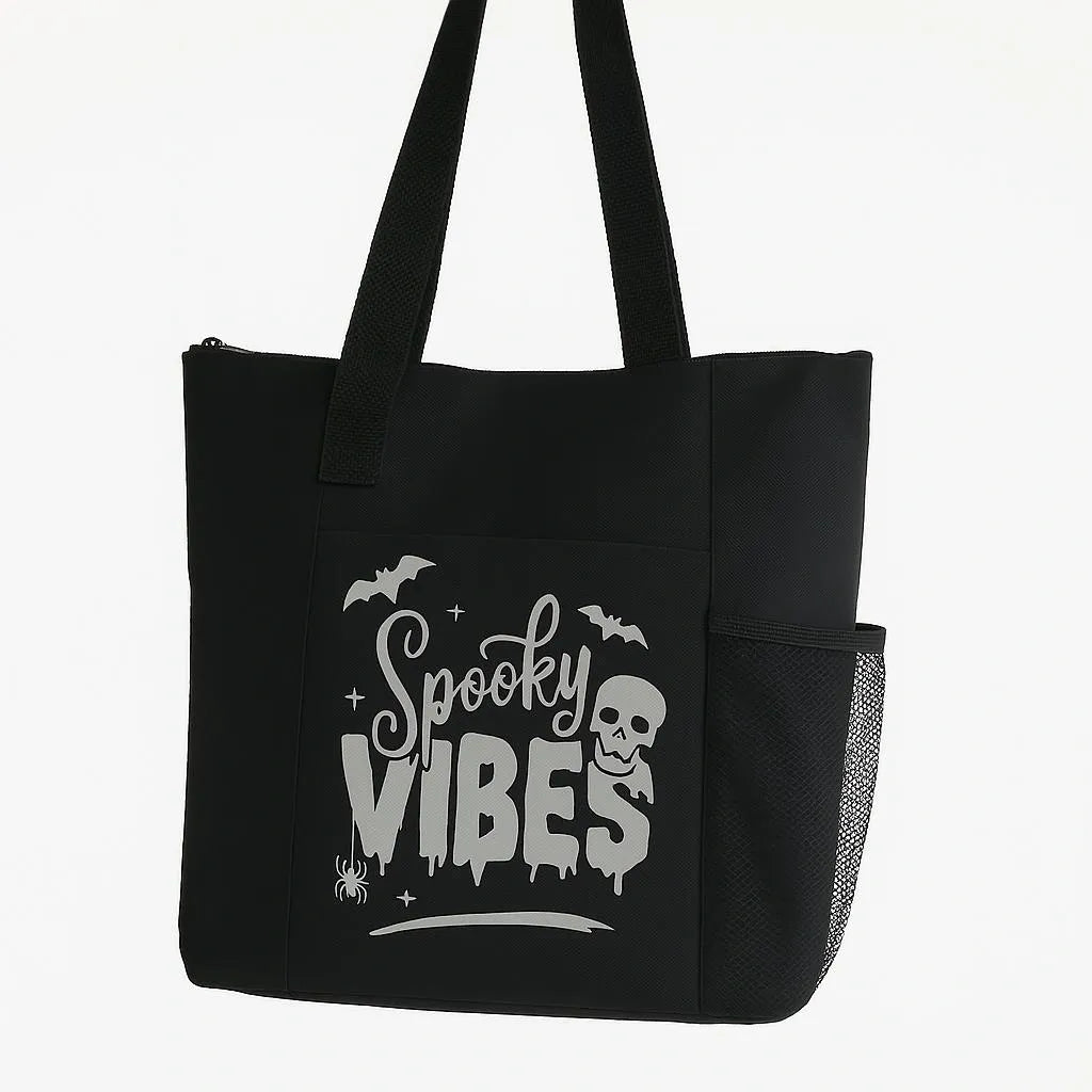 Black tote bag featuring a white Spooky Vibes graphic design on the front. Lightweight reusable shoulder tote with long handles for comfortable carrying. Perfect for Halloween lovers, spooky season fans, shopping, books, work, travel, errands, and everyday use. Stylish gothic-inspired tote bag with a fun spooky aesthetic that stands out against the black background. Ideal for witchy fashion lovers, Halloween enthusiasts, and fans of alternative style.