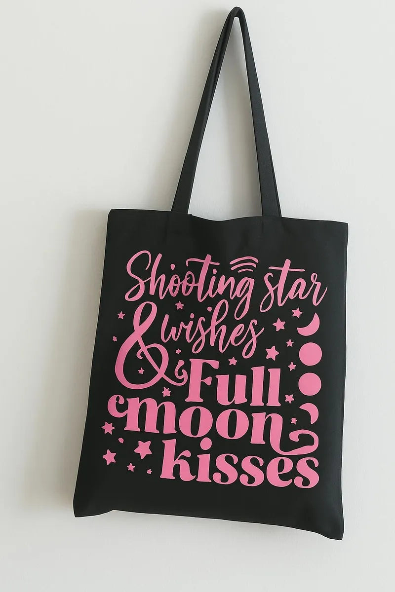 Black cotton tote bag with pink Starlight and Full Moon Kisses graphic design, reusable celestial shoulder bag for shopping, travel, school, astrology lovers, and moon aesthetic fashion.