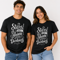 A man and a woman modeling matching black graphic t-shirts with the white text 'Stars! CAN'T Shine WITHOUT Darkness' on the front, set against a plain light background.