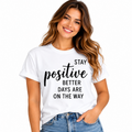 Woman wearing a white Stay Positive T-shirt with black Better Days Are On The Way lettering.