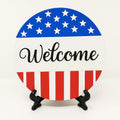 Round welcome patriotic coaster with American flag inspired red white and blue design, decorative welcome table coaster for patriotic home décor, farmhouse coffee table accessory, USA themed summer decoration, patriotic entryway décor, Fourth of July tabletop accent, Americana style drink coaster, festive home decoration for Memorial Day and Independence Day gatherings, patriotic hostess gift and seasonal home décor accessory.