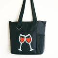 Black reusable tote bag with two wine glasses and heart graphic design, shoulder tote for shopping, travel, everyday carry, wine lovers, romantic gifts, casual outings, and stylish lifestyle accessories